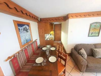 a living room with a table and a couch at La Ginabelle – vue Mont Blanc avec piscine in Chamonix-Mont-Blanc