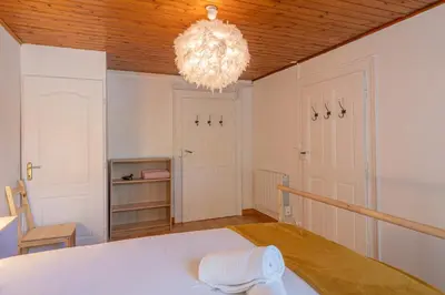 a room with a white bed and a chandelier at Rimaye Blanche - A bright and cozy 1 bed apartment in Chamonix-Mont-Blanc