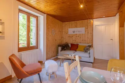 a living room with a couch and a table at Rimaye Blanche - A bright and cozy 1 bed apartment in Chamonix-Mont-Blanc