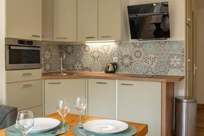 a kitchen with a table with two plates and wine glasses at Bois des Fées - newly renovated central Chamonix apartment in Chamonix-Mont-Blanc