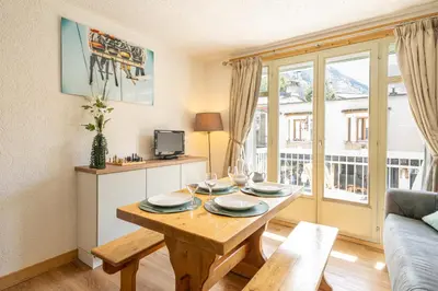 a living room with a table with wine glasses on it at Bois des Fées - newly renovated central Chamonix apartment in Chamonix-Mont-Blanc