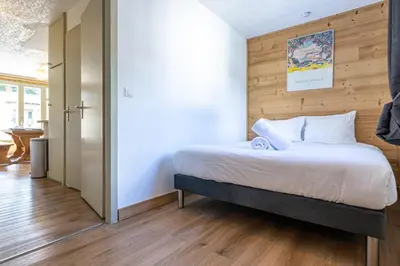 a bedroom with a bed with a wooden wall at Bois des Fées - newly renovated central Chamonix apartment in Chamonix-Mont-Blanc
