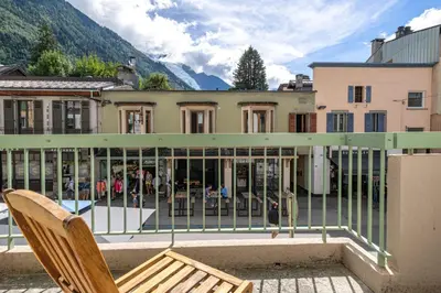 a balcony with a chair and a building at Bois des Fées - newly renovated central Chamonix apartment in Chamonix-Mont-Blanc