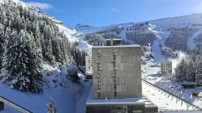a building in the snow next to a mountain at Résidence Vega - Studio lumineux · Proche des pistes et des commerces · Balcon MAE-1641 in Magland