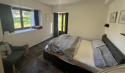 a bedroom with a bed and a chair and a window at Chalet La Foge - Samoens x 14, skis aux pieds in Morillon