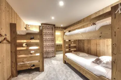 two bunk beds in a room with wooden walls at Picherie bas - 10Pax - Calme - Vue montagne in Saint-Gervais-les-Bains