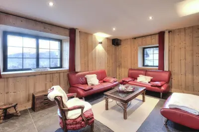 a living room with red couches and a table at Picherie bas - 10Pax - Calme - Vue montagne in Saint-Gervais-les-Bains