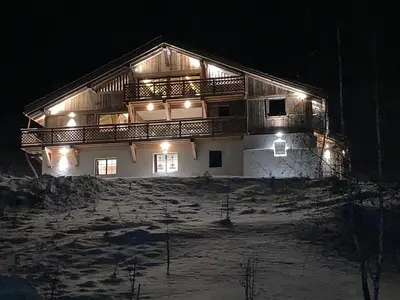 a house with a balcony on a hill at night at Picherie bas - 10Pax - Calme - Vue montagne in Saint-Gervais-les-Bains