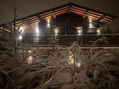 a house covered in snow at night with lights at Chalet Le 1853 in Chamonix-Mont-Blanc