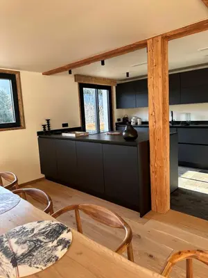 a kitchen with black cabinets and a table and chairs at Chalet Le 1853 in Chamonix-Mont-Blanc