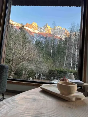 a bowl of fruit on a table in front of a window at Chalet Le 1853 in Chamonix-Mont-Blanc