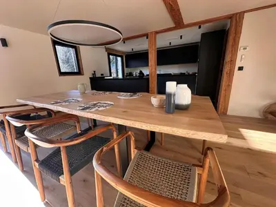 a wooden table and chairs in a room with a kitchen at Chalet Le 1853 in Chamonix-Mont-Blanc