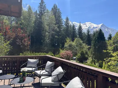 a balcony with chairs and tables and a mountain at Chalet Le 1853 in Chamonix-Mont-Blanc