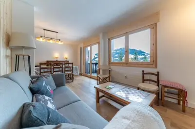 a living room with a blue couch and a table at Appartement à Megève skis aux pieds - La CABOCHE in Le Planellet