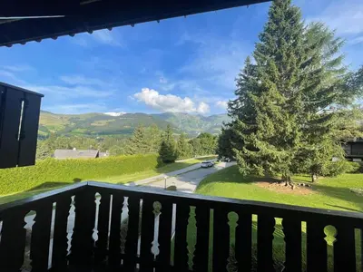 a view from the balcony of a house with a christmas tree at Appartement à Megève skis aux pieds - La CABOCHE in Le Planellet
