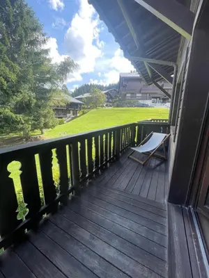 a deck with a bench on the side of a house at Appartement à Megève skis aux pieds - La CABOCHE in Le Planellet