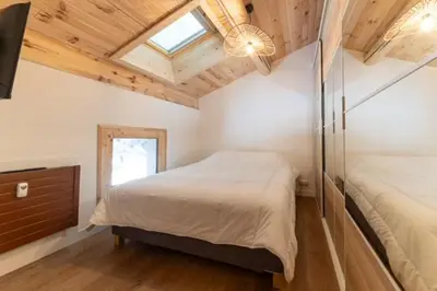 a bedroom with a bed and a dresser and a window at Appartement à Megève skis aux pieds - La CABOCHE in Le Planellet