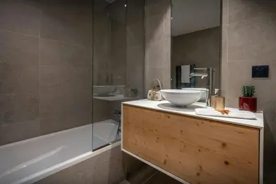 a bathroom with a tub and a sink and a bath tubermottermott at Sundance Kid Loft - OVO Network in Megève