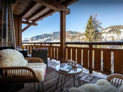 a screened in porch with a table and chairs at Sundance Kid Loft - OVO Network in Megève