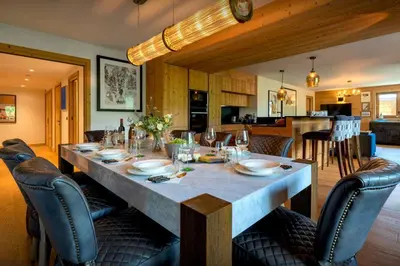 a dining room with a table and chairs and a kitchen at Sundance Kid Loft - OVO Network in Megève