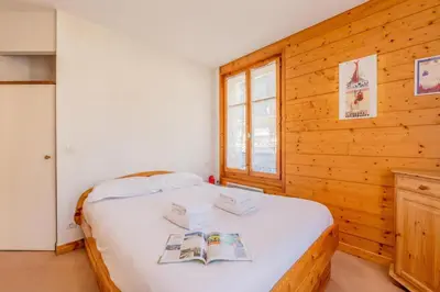a bedroom with a bed with two books on it at Appartement De l'Aiguille Du Midi - Happy Rentals in Chamonix-Mont-Blanc