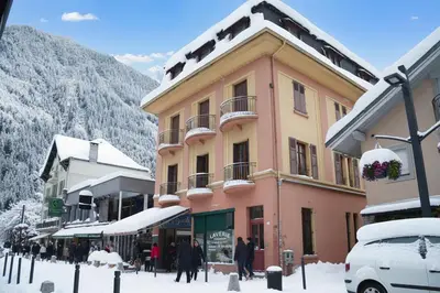 a building on a street with people walking in the snow at Appartement De l'Aiguille Du Midi - Happy Rentals in Chamonix-Mont-Blanc