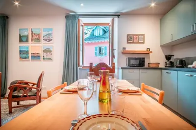 a dining room table with a bottle and glasses on it at Le Rocher - Chamonix Hypercentre - Refait à Neuf in Chamonix-Mont-Blanc