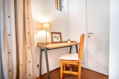 a table with a lamp and a chair in a room at Le Rocher - Chamonix Hypercentre - Refait à Neuf in Chamonix-Mont-Blanc