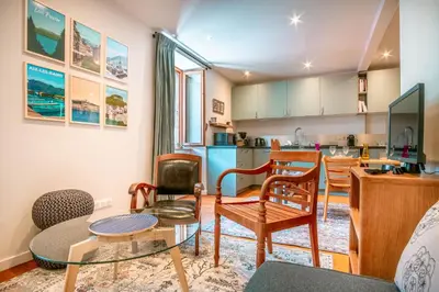 a living room with a table and chairs and a kitchen at Le Rocher - Chamonix Hypercentre - Refait à Neuf in Chamonix-Mont-Blanc