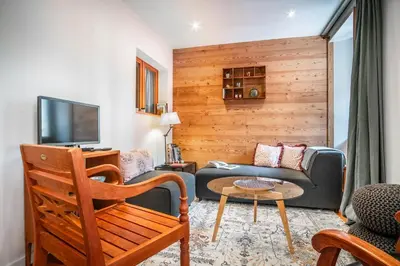 a living room with a couch and a table at Le Rocher - Chamonix Hypercentre - Refait à Neuf in Chamonix-Mont-Blanc