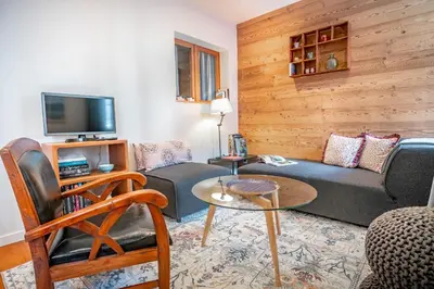 a living room with a couch and a tv at Le Rocher - Chamonix Hypercentre - Refait à Neuf in Chamonix-Mont-Blanc