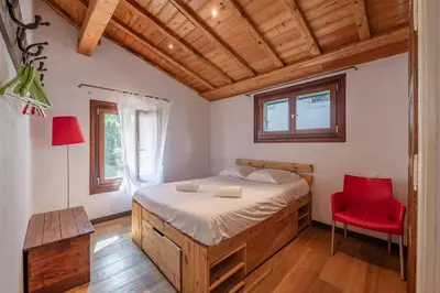 a bedroom with a bed and a red chair at Spacious loft on pedestrian street with views in Chamonix-Mont-Blanc
