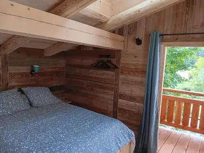 a bedroom with a bed in a log cabin at Chalet rinette in Chamonix-Mont-Blanc