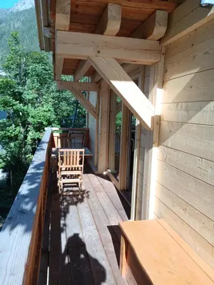 a porch of a wooden cabin with two chairs at Chalet rinette in Chamonix-Mont-Blanc