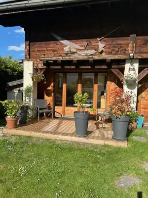 a house with potted plants on a wooden deck at Beau studio dans la vallée de CHAMONIX in Les Houches
