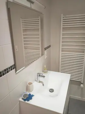 a white bathroom with a sink and a mirror at Beau studio dans la vallée de CHAMONIX in Les Houches