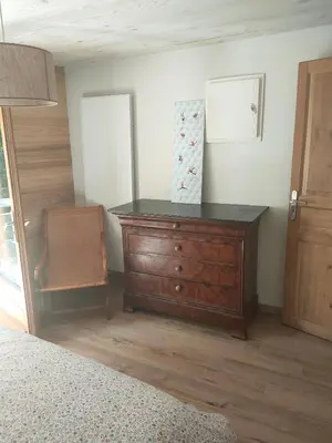 a bedroom with a wooden dresser in a room at Beau studio dans la vallée de CHAMONIX in Les Houches