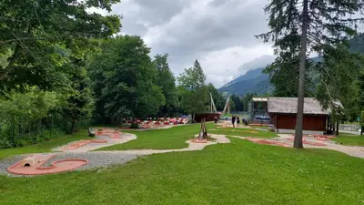 a park with benches and a building and trees at Studio cosy au pied des remontées,wifi,smart TV,parking in Les Contamines-Montjoie