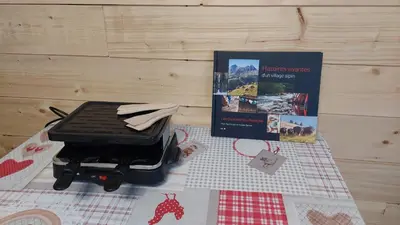 a grill sitting on a table with a book at Studio cosy au pied des remontées,wifi,smart TV,parking in Les Contamines-Montjoie