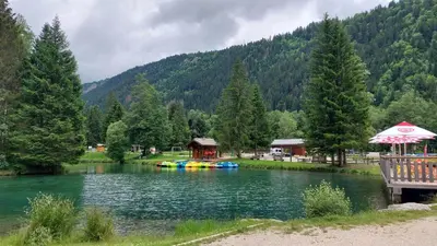 a lake with a house and a group of rafts at Studio cosy au pied des remontées,wifi,smart TV,parking in Les Contamines-Montjoie