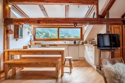 a wooden deck with benches on a balcony with mountains at Le Hameau de Taconnaz - Calme - Charme in Les Houches