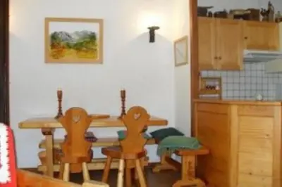 a kitchen with a wooden table and chairs in a room at Les Appartements Diochon in Le Baplieu