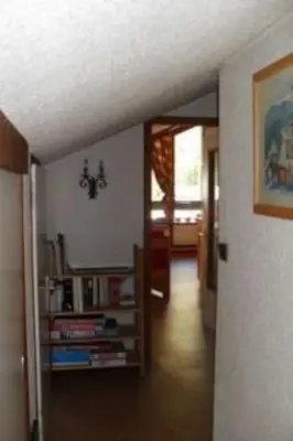 a hallway of a house with a room with a book shelf at Les Appartements Diochon in Le Baplieu