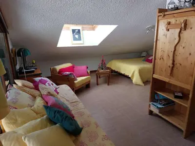 a bedroom with two beds and a skylight at Les Appartements Diochon in Le Baplieu