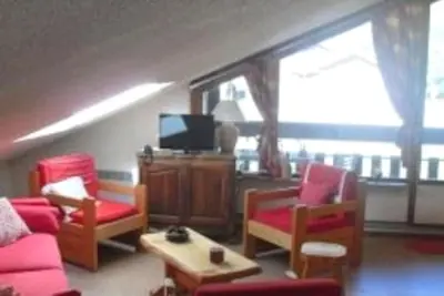 a living room with a couch and chairs and a tv at Les Appartements Diochon in Le Baplieu