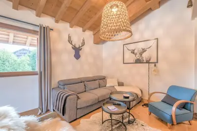 a living room with a couch and a chair at Appartement du Meu - Welkeys in Megève
