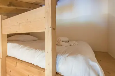 a bunk bed with white sheets and towels on it at Appartement du Meu - Welkeys in Megève