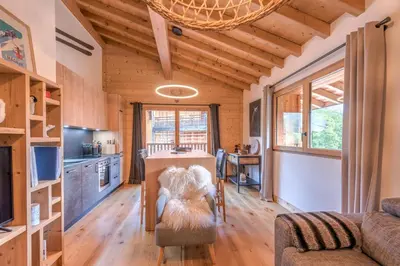 a kitchen and living room with a table in a house at Appartement du Meu - Welkeys in Megève