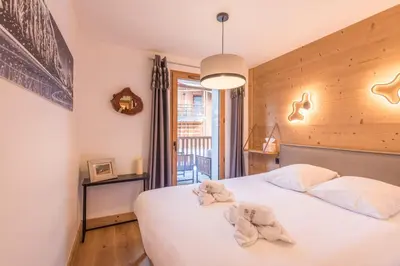 a bedroom with a bed with towels on it at Appartement du Meu - Welkeys in Megève