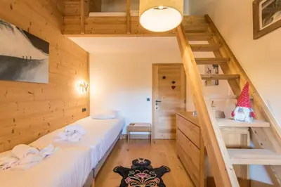 a room with two beds and a staircase at Appartement du Meu - Welkeys in Megève